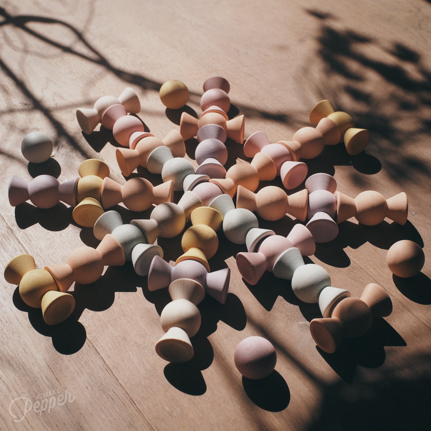 A mandala on a wooden floor made of Chill Pepper Sweets. A sustainable wooden stacking and loose parts toy set in the shape of candy. For open ended play.