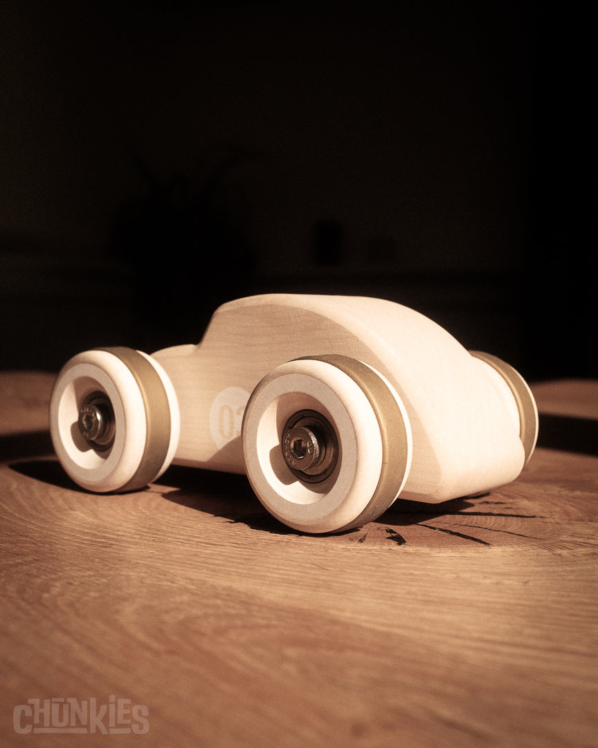 3/4 back view of the curvy Chunkies Bug made by Chill Pepper in Europe. A solid wooden toy car for kids and collectors